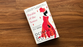 A paperback copy of Parable of the Sower against a wood floor.