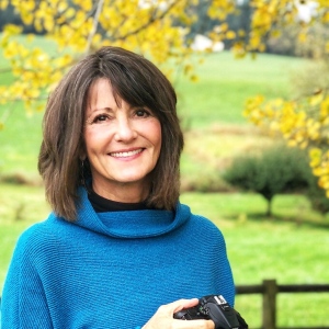 A photo of author Cheryl Grey Bostrom holding a camera.